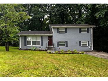 Charming home featuring a well-manicured lawn, gray brick facade and neatly trimmed shrubbery at 2436 Glenrock Dr, Decatur, GA 30032
