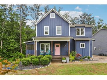 Charming two-story home featuring a pink door and inviting front porch with seating at 1916 River Birch Ln, Atlanta, GA 30316