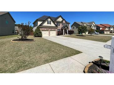 Traditional two-story brick home with a two-car garage and a well-manicured front yard on a sunny day at 2030 Hydrangea Ln, Austell, GA 30106