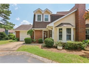 Charming home featuring a brick facade, well-manicured lawn and two-car garage on a sunny day at 107 Mary Gay Ct, Decatur, GA 30030