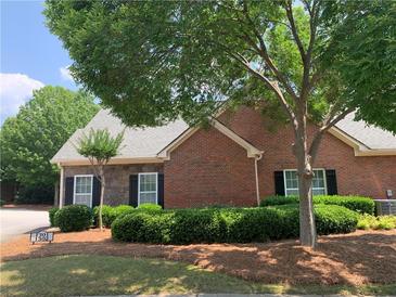 Charming brick home with stone accents, well-manicured landscaping and mature trees for shade at 1301 Haven Cir, Douglasville, GA 30135