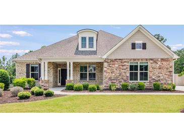 Charming single-story home with a stone facade, well-manicured lawn, and lovely landscaping at 1374 Highland Wood Ct, Auburn, GA 30011