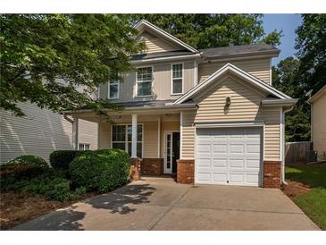 Charming two-story home with a well-maintained lawn, attached garage, and inviting front porch at 208 Oconee Way, Canton, GA 30114