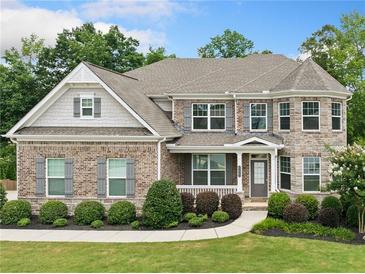 Charming two-story brick home features manicured landscaping and a welcoming front porch at 127 Sanctuary Ave, Woodstock, GA 30188