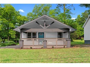 Charming home with a welcoming front porch, complemented by a beautifully maintained lawn and fresh landscaping at 2209 Browns Mill Se Rd, Atlanta, GA 30315
