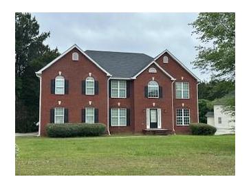 Charming two-story red brick home with a well-manicured front lawn and classic architectural details at 10175 Hemlock Way, Jonesboro, GA 30238