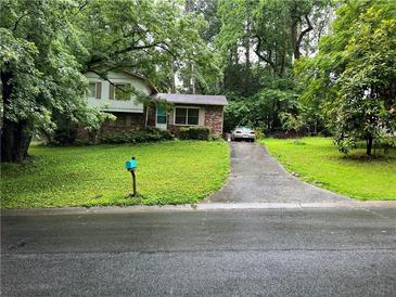 Charming split-level home with brick accents, lush lawn, and a long driveway at 3317 Shady Oak Dr, Atlanta, GA 30340