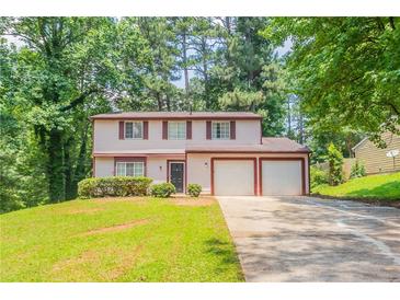 Charming two-story home featuring a well-manicured lawn, mature trees, and an attached two-car garage at 5092 Stone Trce, Stone Mountain, GA 30083