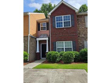 Charming multi-level townhome featuring a brick facade and manicured landscaping at 2612 Haligan Pt, Riverdale, GA 30296