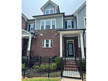 Charming three-story townhome with brick facade and black metal fencing, creating a welcoming curb appeal at 2734 Bell Se Dr, Smyrna, GA 30080