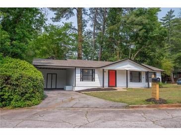 Charming single-story home with a vibrant red front door, driveway, and a well-maintained lawn at 4922 Glenside Ct, Stone Mountain, GA 30088