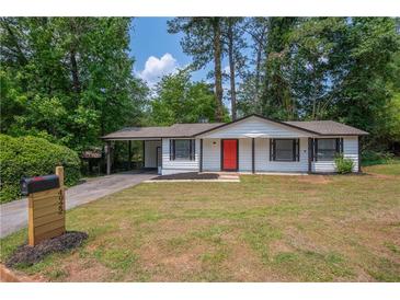 Charming single-story home with a well-maintained lawn, a mailbox and a vibrant red front door at 4922 Glenside Ct, Stone Mountain, GA 30088