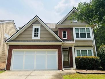 Charming two-story home with a brick and siding exterior and an attached two-car garage at 210 Morning Dove Ln, Suwanee, GA 30024