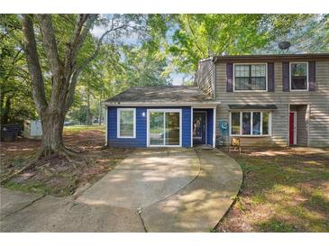 Charming townhome with a blue and tan exterior, complemented by a concrete driveway and mature trees at 3799 Henry Ct, Acworth, GA 30101