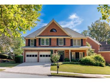 Charming two-story brick home features a two-car garage and well-manicured landscaping at 4729 Woodland Brook Se Ct, Atlanta, GA 30339