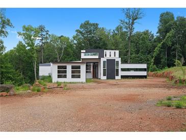 Modern home with geometric design, clean lines, and minimalist aesthetic set in a wooded lot at 5210 Brownlee Rd, Stone Mountain, GA 30087