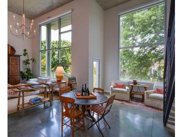 Bright living room featuring large windows, chandelier, and a seating area with a round table and concrete floors at 850 Ralph Mcgill Ne Blvd # 6, Atlanta, GA 30306