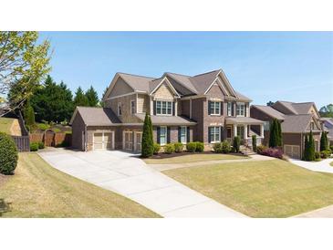 Beautiful two-story home featuring a manicured lawn, two-car garage, and brick-and-siding facade at 622 Rocky Creek Pt, Woodstock, GA 30188