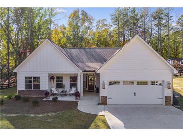 Charming home with white siding, stone accents, and a welcoming front porch with chairs at 728 Harmony Rd, Temple, GA 30179