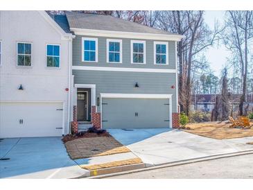 Charming townhome featuring a two-car garage, neutral paint, and a welcoming entrance, perfect for modern living at 174 Bluffington Way, Marietta, GA 30066
