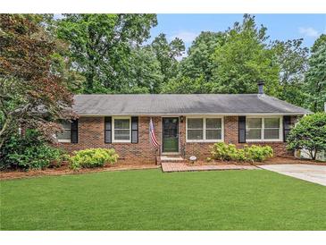Charming brick ranch with manicured lawn, mature landscaping, and welcoming front entrance at 286 Indian Trl, Marietta, GA 30068