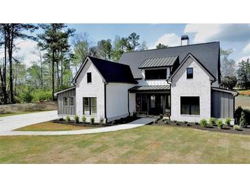 Stunning two-story home boasts a modern farmhouse design with black trim and a manicured front lawn at 115 Palisade Dr, Rydal, GA 30171