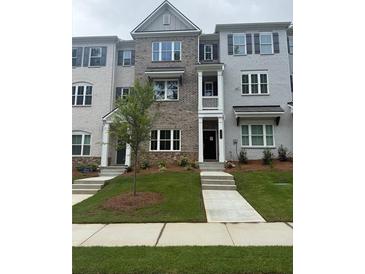 Charming townhome with brick and painted facade, landscaped front yard, and inviting entryway at 1956 Deco Dr, Kennesaw, GA 30144