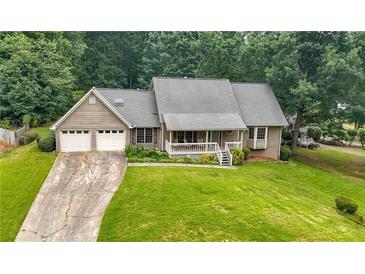 Charming home featuring a two-car garage, front porch, and lush landscaping at 2868 Wood Park Nw Trce, Kennesaw, GA 30152