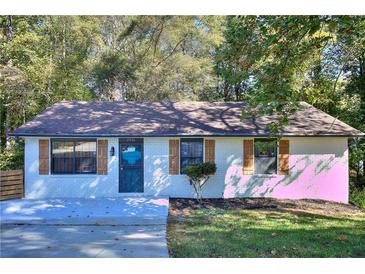 Charming home featuring a brick facade, symmetrical windows, and decorative shutters at 2066 Tidwell Trl, Stone Mountain, GA 30088