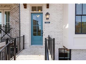 Charming light blue front door with glass panes, black lantern, and brick facade at 530 Fisher Dr # 45, Alpharetta, GA 30009