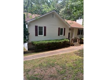 Charming single-story home featuring beige siding, red shutters, landscaped yard, and inviting front porch at 291 N Briar Rdg, Woodstock, GA 30189