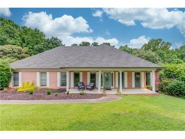 Charming brick home with a covered porch, white columns, and manicured front lawn at 2005 Ashton Pointe Dr, Dacula, GA 30019