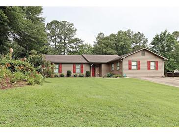 Charming single-story home with a well-manicured lawn, colorful landscaping, and inviting red shutters and door at 199 Candy Ln, Canton, GA 30115
