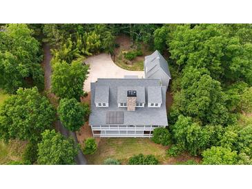 Stunning aerial view of home with grey shingles, private driveway, lush trees and manicured lawn at 2216 Trammel Rd, Cumming, GA 30041
