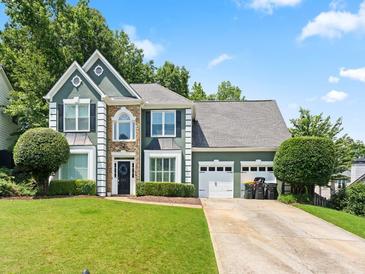 Two-story home with manicured lawn and three-car garage and a driveway with nice curb appeal at 530 Camber Woods Dr, Roswell, GA 30076