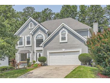 Charming two-story home featuring a well-maintained lawn, attached two car garage, and mature trees at 750 Gates Ln, Alpharetta, GA 30022
