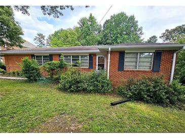 A single story brick home with black shutters and a well-maintained lawn under a cloudy sky at 2480 Sewell Mill Rd, Marietta, GA 30062