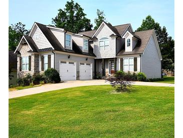 Charming two-story home featuring a well-manicured lawn, two-car garage, and stone accents at 50 Worthington Dr, Villa Rica, GA 30180