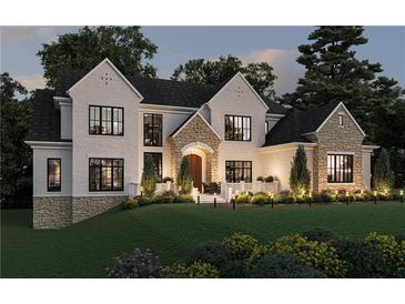 Elegant two-story home featuring a stone and white brick facade, well-manicured lawn, and beautiful landscaping at 120 Wood River Ct, Johns Creek, GA 30097
