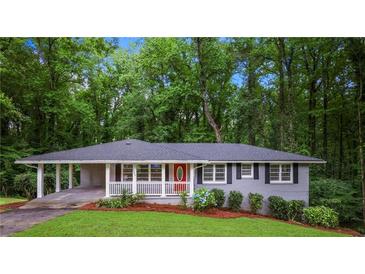 Charming single-story home with a covered carport, landscaped front yard, and red front door at 2383 Edgewater Sw Dr, Atlanta, GA 30311
