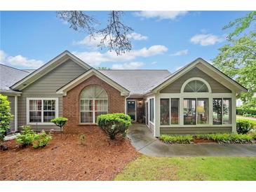 Charming one-story home with brick accents, landscaped yard, and inviting sunroom in a well-manicured neighborhood at 4512 Orchard Trce, Roswell, GA 30076