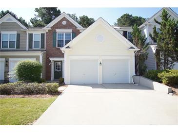 Charming townhouse featuring a two-car garage and manicured landscaping at 2426 Fairlie Dr, Duluth, GA 30096