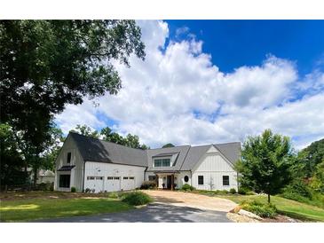 Stunning white farmhouse with a three-car garage and an asphalt driveway at 3842 Ernest W Barrett Sw Pkwy, Marietta, GA 30064