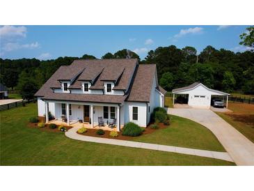 Beautiful, modern farmhouse-style home with a well-manicured lawn and separate garage at 3508 Cox Cemetery Rd, Social Circle, GA 30025