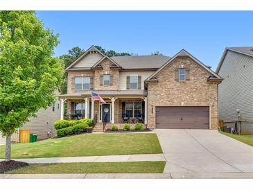 Traditional two-story brick home with a welcoming front porch and well-manicured lawn at 406 Fernstone Dr, Canton, GA 30114