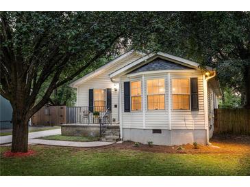 Charming home with a well-manicured lawn, bay windows, and covered front porch seating area at 901 Winfield Se Ave, Atlanta, GA 30316