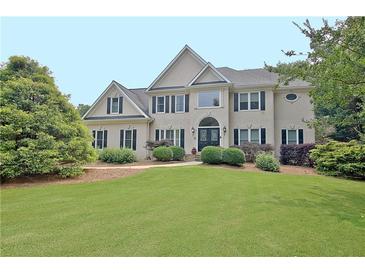 Stately two-story home featuring a lush green lawn and manicured landscaping at 104 Hidden Springs Ln, Peachtree City, GA 30269