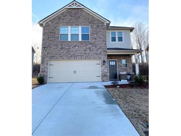 Two-story brick home featuring a two-car garage and well-maintained front yard at 2757 Malton Way, Loganville, GA 30052