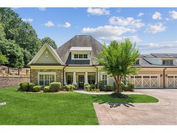 Charming home featuring stone accents, a lush lawn, and a three car garage at 2855 Middlecreek Way # 2855, Cumming, GA 30041