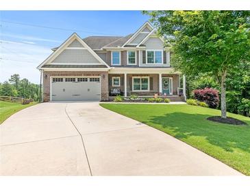 Charming two-story home with a well-manicured lawn and a long driveway leading to an attached two-car garage at 466 Sweet Apple Ln, Buford, GA 30518